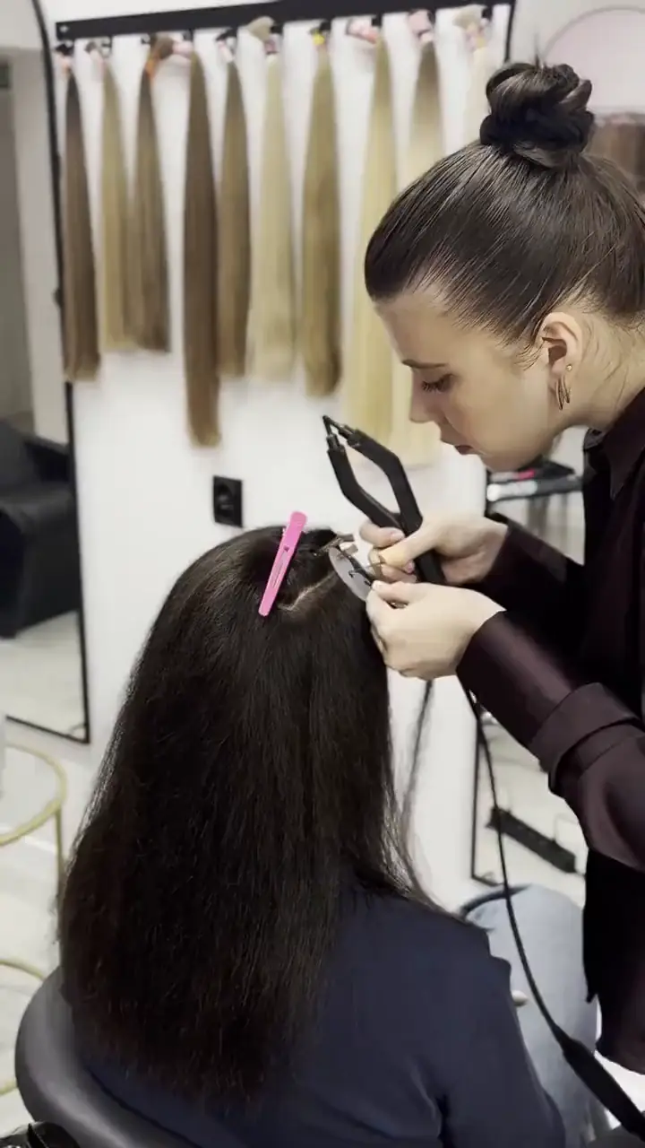 Stylistka zakłada pasma kapsułkami micro przy ścianie odcieni