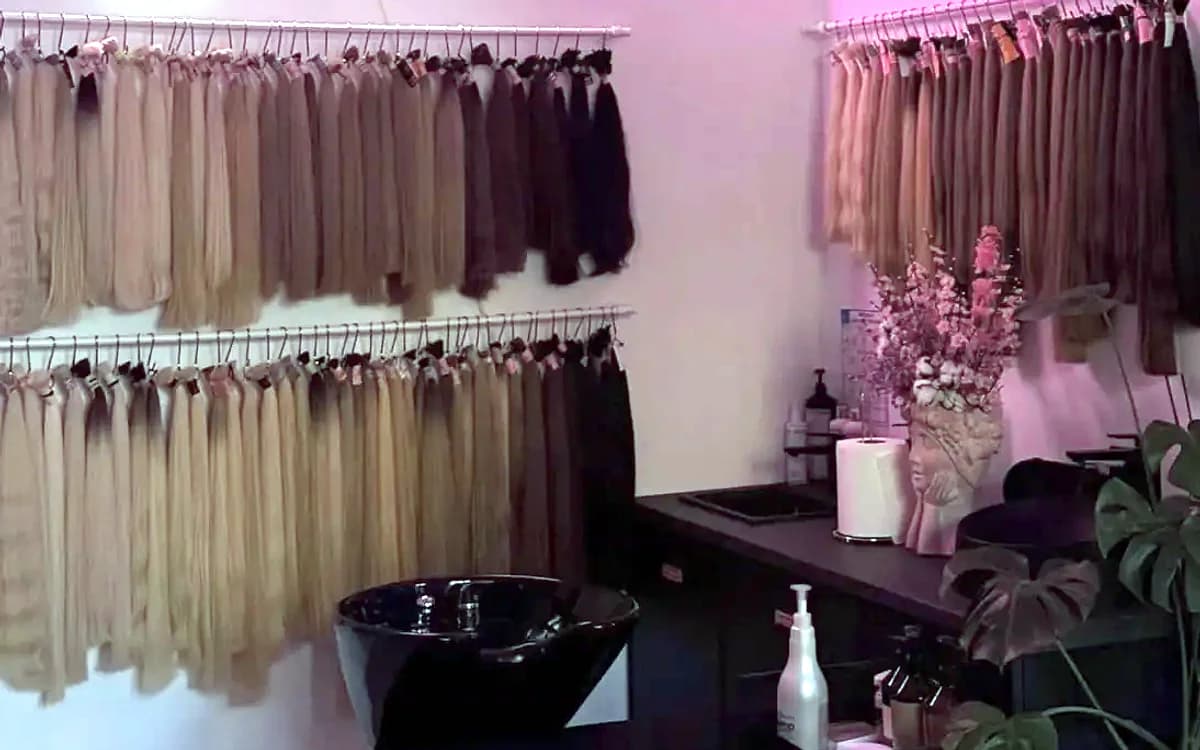 Ściana z paletą odcieni pasm w salonie Glam Hair Studio